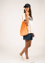 Load image into Gallery viewer, Model holding Saint James Sac Filet in Orange/Ecru