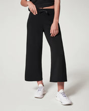 Load image into Gallery viewer, Model wearing Spanx - Air Essentials Cropped Wide Leg Pant in Black.
