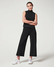 Load image into Gallery viewer, Model wearing Spanx - Air Essentials Cropped Wide Leg Pant in Black.
