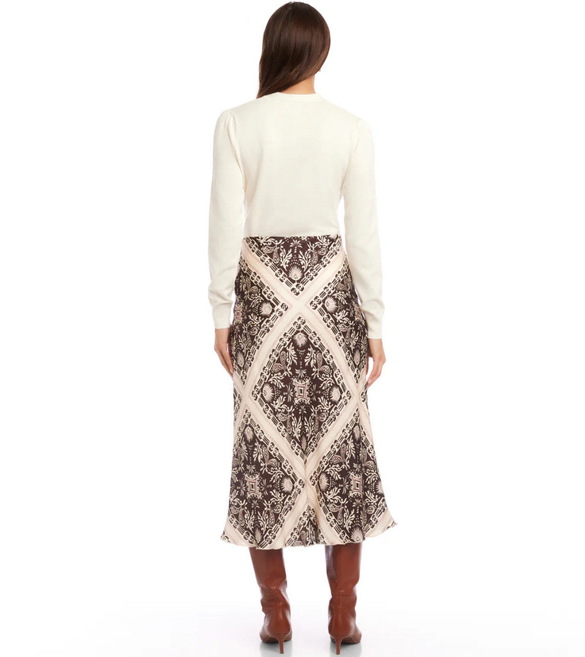 Woman wearing a patterned skirt and white top on a white background