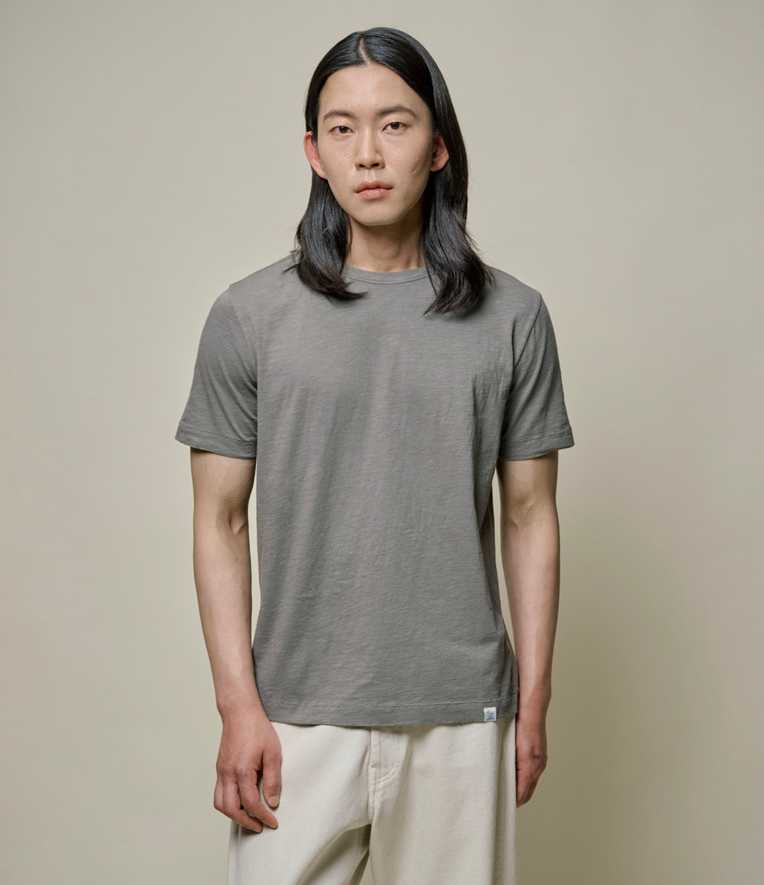 Model wearing Merz B. Schwanen - Good Basics Unisex T-shirt in Vintage Army.