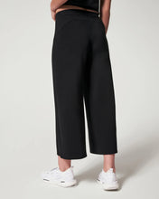 Load image into Gallery viewer, Model wearing Spanx - Air Essentials Cropped Wide Leg Pant in Black - back.

