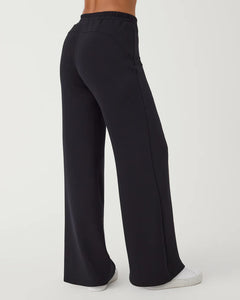 Model wearing Spanx - Air Essentials Wide Leg Pant in Very Black - back.