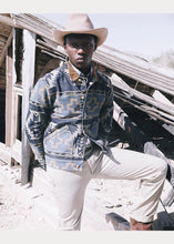 Load image into Gallery viewer, Model wearing RRL - Valero Cotton Indigo Denim Jacquard Trucker Jacket in Indigo/Yellow/Tan Multi.
