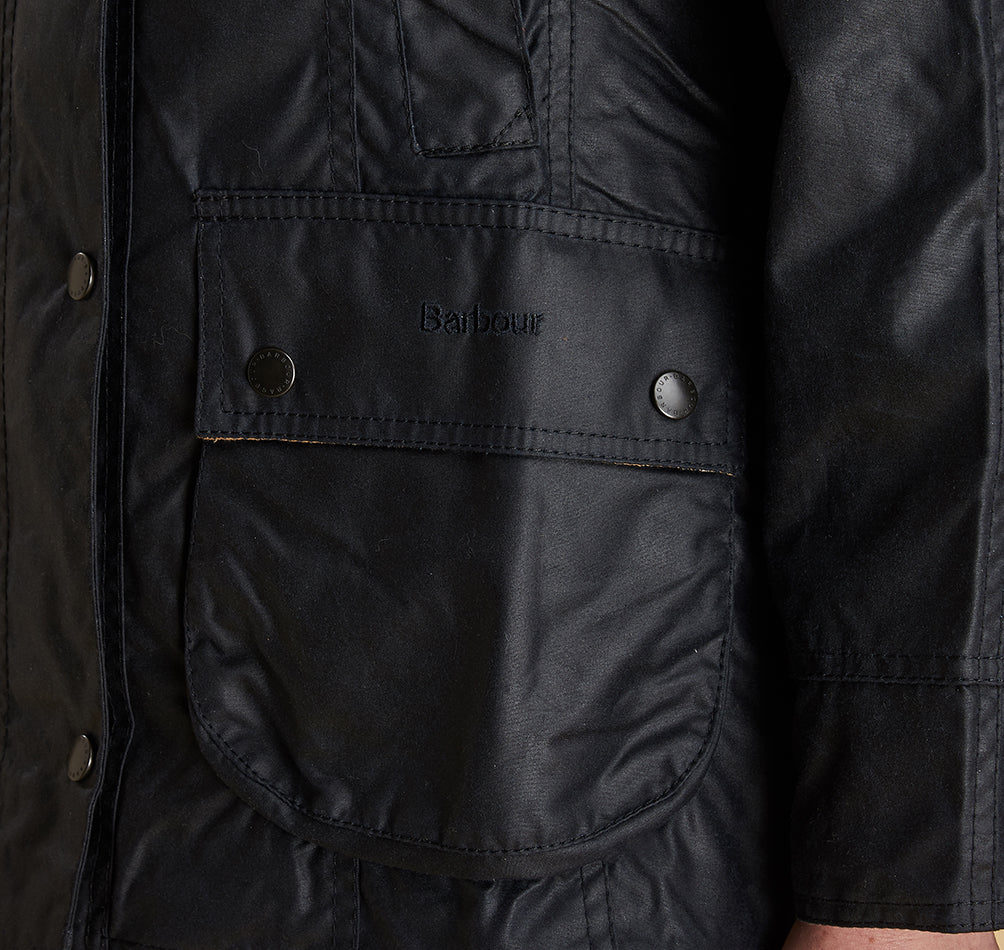 Model wearing Barbour Beadnell wax jacket in navy.