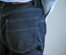 Load image into Gallery viewer, Model wearing Raleigh Denim Jones Resin Rinse jeans featuring back pocket..
