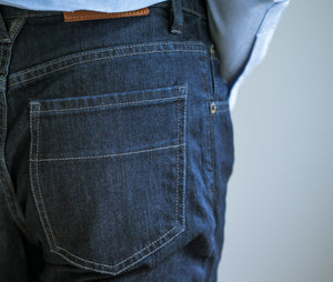 Model wearing Raleigh Denim Jones Resin Rinse jeans featuring back pocket..