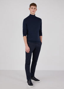 Model wearing Sunspel Merino Roll Neck Jumper in Light Navy.